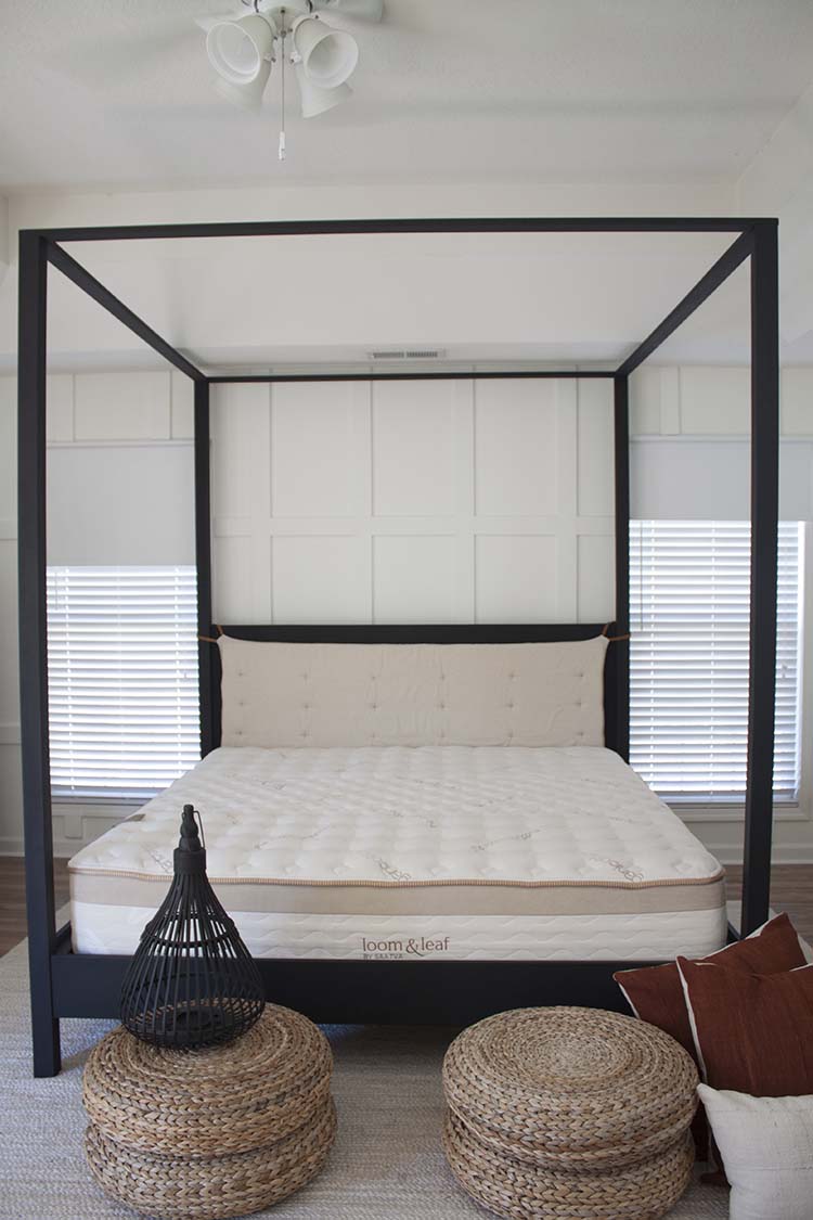 white room black canopy bed floor pillows